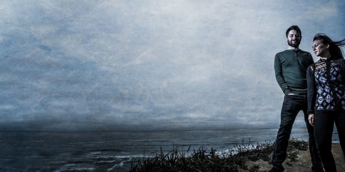 Engagement photo of young couple overlooking the ocean.