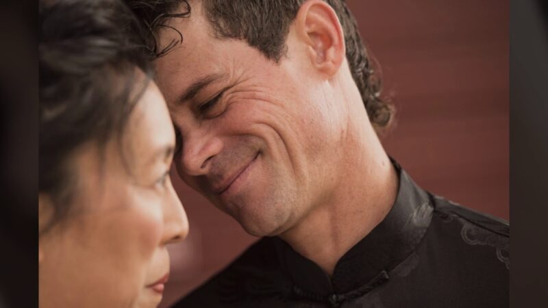 A man and woman are smiling at each other.