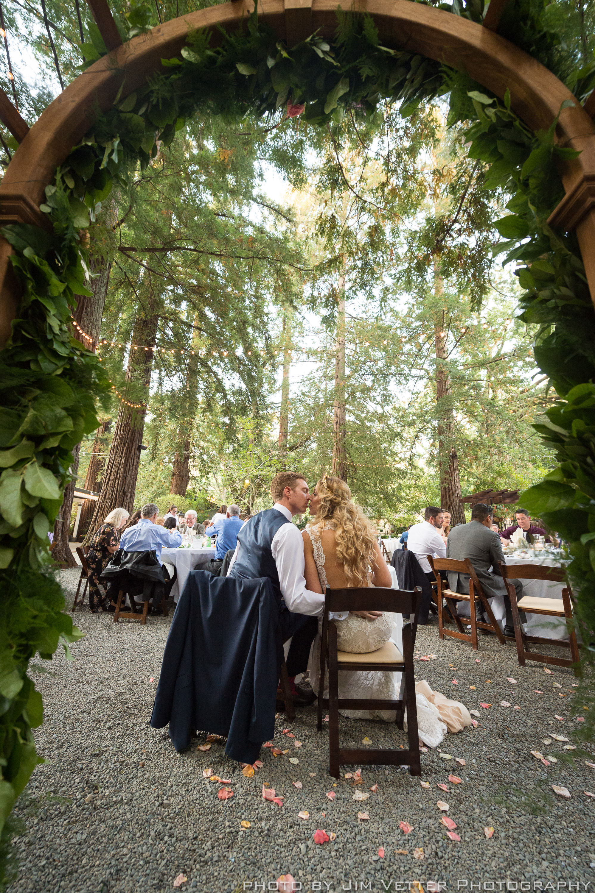 bride and groom kissing under arch at sweetheart table deer park villa fairfax