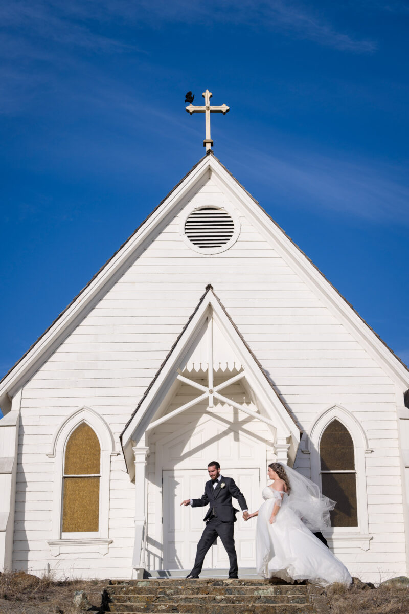 a bride and groom walking up the steps of a church.