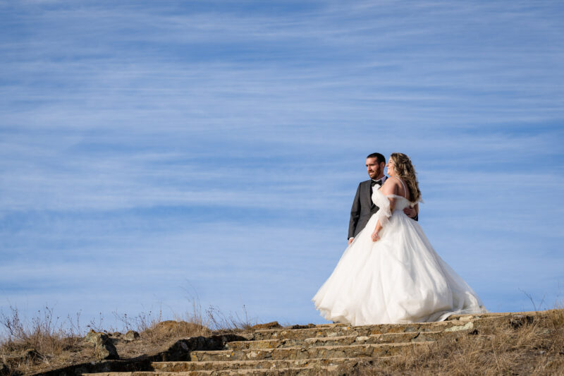 a bride and groom standing on some steps.