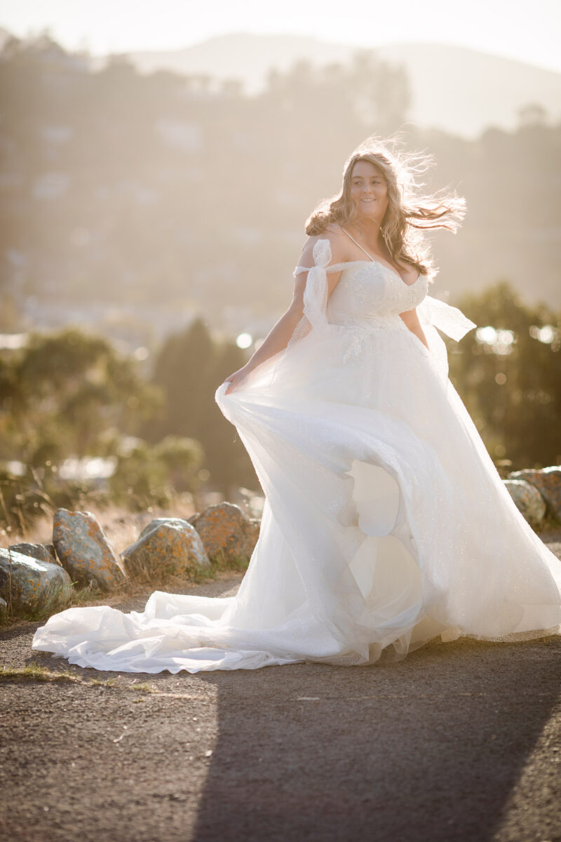 a bride in a white dress is posing for a picture.