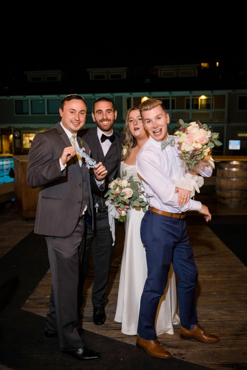 a bride and groom pose for a picture with their friends.