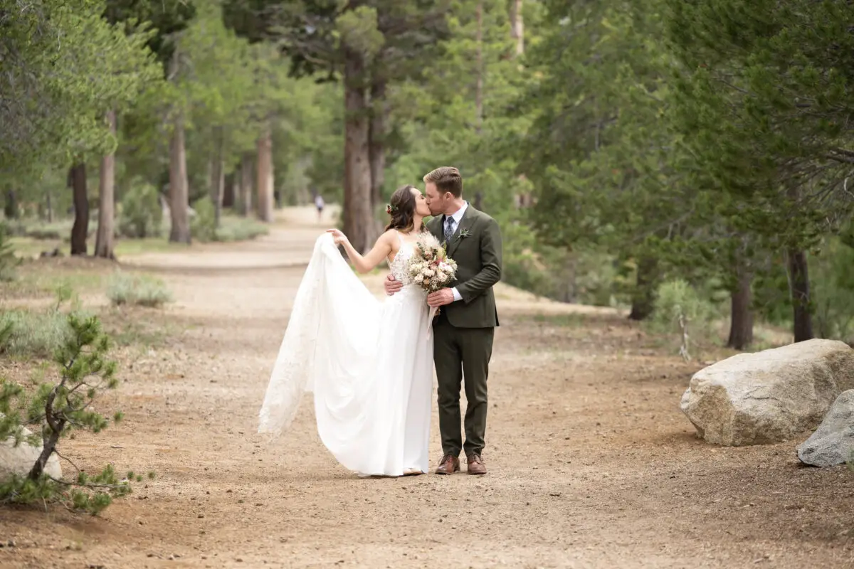 Bride and Groom kissing on path in woods