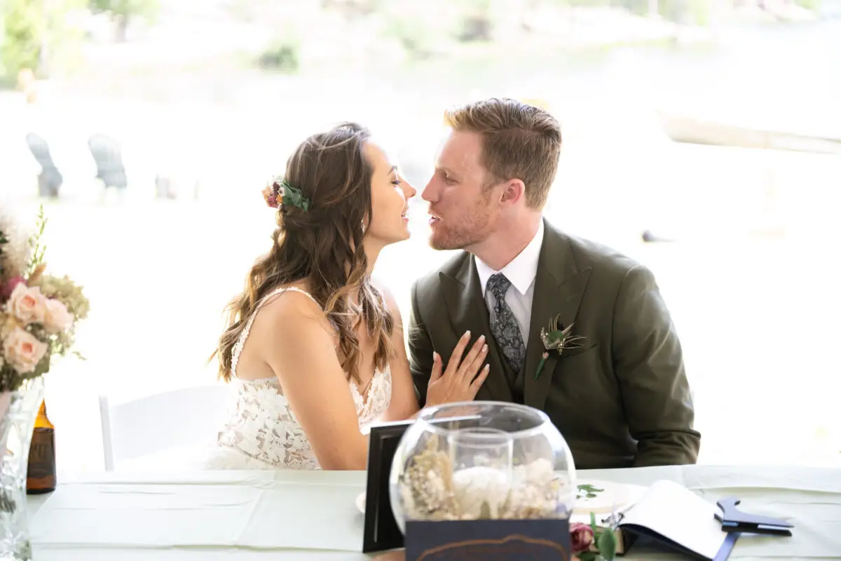 Bride and Groom kissing at sweetheart table