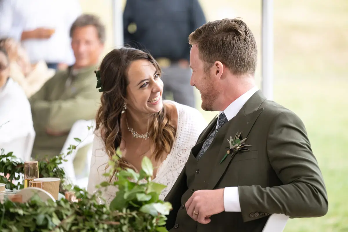 Bride and Groom laughing at sweetheart table