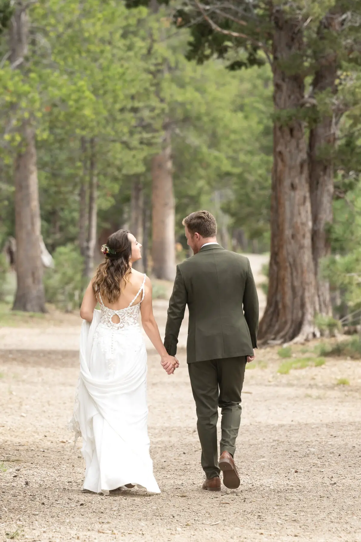 Bride and Groom walking away on path in woods